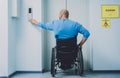 Person with a physical disability who uses wheelchair using lift in building