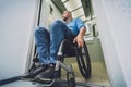 Person with a physical disability who uses wheelchair using lift in building