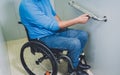 Person with a physical disability who uses wheelchair using lift in building