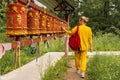 Person pilgrim woman touching turning spinning Buddhist prayer wheel at Buddhist monastery. Prayer wheels in Buddhist