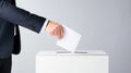 The person places a ballot for the election of president, senator or deputy into a white ballot box.