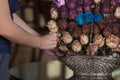 person placing a flower in arrangement with dried flowers