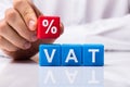 Person Placing Red Percentage Block Over Vat