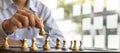 Person playing chess board game, business man concept image holding chess pieces like business competition and risk management, Royalty Free Stock Photo