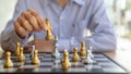 Person playing chess board game, business man concept image holding chess pieces like business competition and risk management, Royalty Free Stock Photo