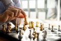 Person playing chess board game, business man concept image holding chess pieces like business competition and risk management, Royalty Free Stock Photo