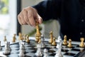 Person playing chess board game, business man concept image holding chess pieces like business competition and risk management, Royalty Free Stock Photo