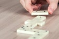 Person playing dominoes on a wooden table Royalty Free Stock Photo