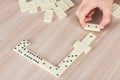 Person playing dominoes on a wooden table Royalty Free Stock Photo