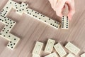 Person playing dominoes on a wooden table Royalty Free Stock Photo