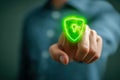 Person pointing at glowing green shield icon with a keyhole symbolizing digital security and data protection in modern technology Royalty Free Stock Photo