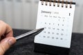 A person pointing at January 12, 2026, on a calendar. The desk setting features a sleek design, emphasizing organization Royalty Free Stock Photo