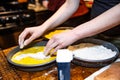 Person pouring batter in a pan with bread in a kitchen. Royalty Free Stock Photo
