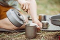 A person pouring hot water for his tea