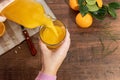 a hand of a person serving orange juice into a glass cup Royalty Free Stock Photo