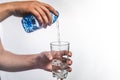 person pouring water in glass over white background Royalty Free Stock Photo