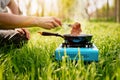 Person preparing meat on camping stove