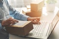 Person preparing online store orders for shipping using laptop