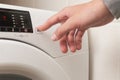 A person is pressing a button on a white washing machine Royalty Free Stock Photo