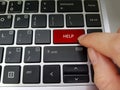A person pressing keyboard key with the word HELP.