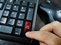 A person pressing the keyboard key with the word `SCAM`