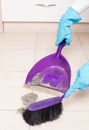 Sweeping tiled floor with brush and dustpan Royalty Free Stock Photo