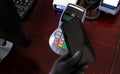 Person in protective latex gloves paying with smartphone in a mobile payment terminal pos card reader, cashless contactless safe