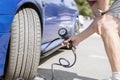 a person pump up the car wheels tires with a compressor with manometer