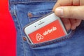 A person putting on a pocket an iPhone Plus with a Airbnb application open