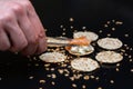 Person putting salmon with sticks on crackers with cream cheese