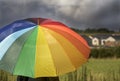 A person with rainbow colored umbrella under storm clouds Royalty Free Stock Photo