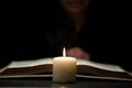 Person Reading thenBible by Candle Light Royalty Free Stock Photo