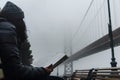 person reading book on bench with bridge fog Royalty Free Stock Photo