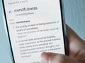 A person reading the definition of mindfulness on a mobile phone