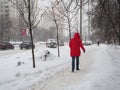 Person in a red down jacket, snow-covered street