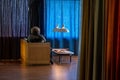 Person relaxing in the comfort of their home with different colored drapes hanging all around