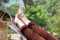 Person relaxing lying in Hammock at rural cottage garden Royalty Free Stock Photo