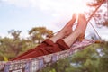 Person relaxing lying in Hammock at rural cottage garden Royalty Free Stock Photo
