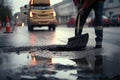 person, repairing pothole in the road surface with shovel