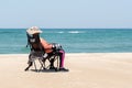 Person resting on a chair at a sandy beach in Crystal Coast, North Carolina, USA