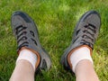 Person resting on the grass after a long walk, detail of legs Royalty Free Stock Photo