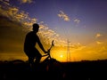A person riding a cycle on a road. Photo captured at the evening time... Person is watching the sunset... Darkness and shadow..