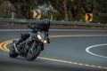 Person riding a motorcycle down a winding road.