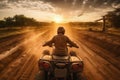 A person is riding a quad bike on a country road, view from behind