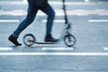 Person riding a scooter in the street throw a pedestrian crossing. Royalty Free Stock Photo