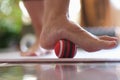 Person rolls ball on foot at home closeup