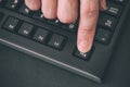 Person`s finger pressing Escape key on a black computer keyboard