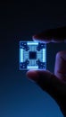 Macro shot of a glowing quantum photonics chip held between fingers, showcasing advanced technology Royalty Free Stock Photo