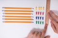 Person`s Hand Arranging Pencils And Multi Colored Pushpins