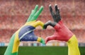 Person`s hand forming a heart with the flags of Brazil and Germany - love towards football concept